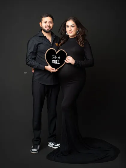 A fun gender reveal shot for this happy couple. Announcing "It's a Girl!" with a cute heart-shaped sign.