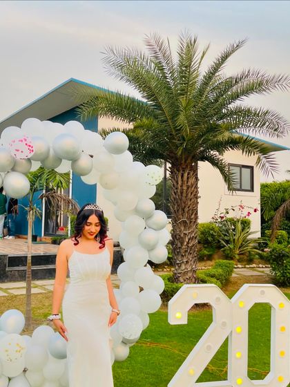 Posing with my "20" marquee lights and birthday decorations. This shot captures the festive atmosphere of my party.