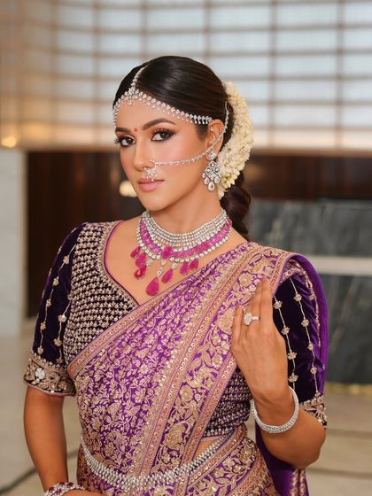 A close-up portrait showing the intricate details of her diamond and ruby jewelry. The makeup is clean and sophisticated, with a focus on enhancing her beautiful features.