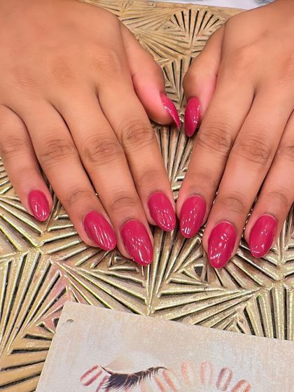 A duplicate of image 83, showing a vibrant set of almond-shaped nails in a deep, glossy magenta color.