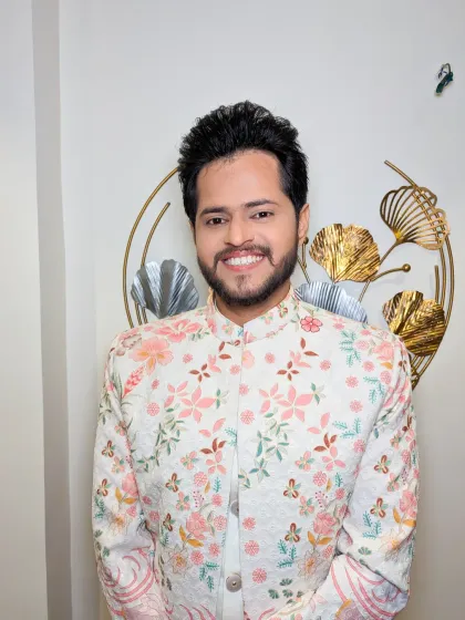 A close-up of the groom's happy face. The light-colored, floral outfit is complemented by a bright and natural makeup look.
