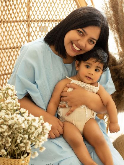 Two hearts, one love. A mother holds her baby girl in a cozy, boho-themed studio setup, perfect for a milestone session.