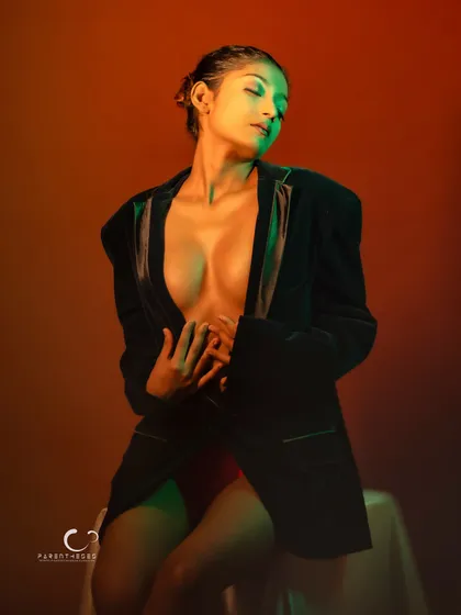 A sensual and artistic portrait using colored gels. The green and orange light paints the skin, creating a surreal and beautiful effect.