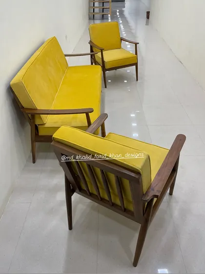 Back view of the yellow armchair, highlighting the wooden spindle back detail.