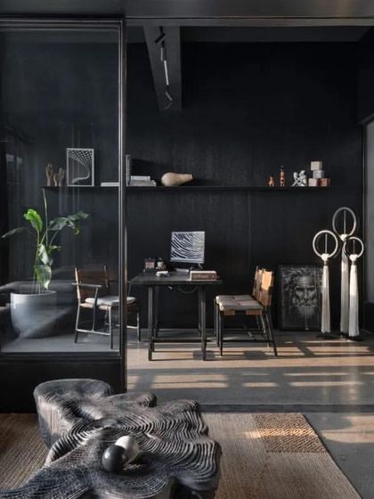 A private cabin within the office is designed with a dark, monolithic theme, creating a focused and contemplative workspace.