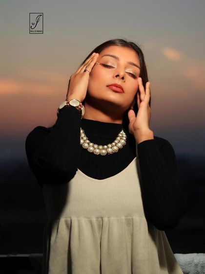 This close-up focuses on the model's expression of tranquility, with the pearl necklace adding a touch of classic elegance.