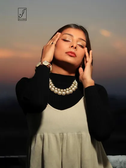 This close-up focuses on the model's expression of tranquility, with the pearl necklace adding a touch of classic elegance.