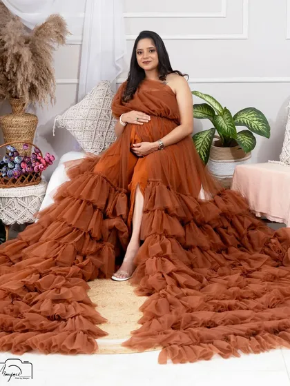 Seated gracefully, this mama-to-be shows off the magnificent train of the brown ruffled gown. A truly stunning and dramatic shot.
