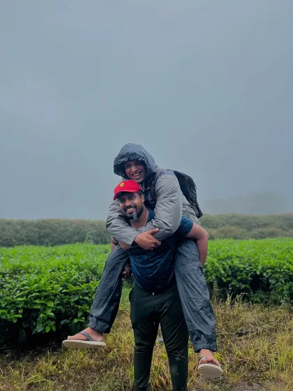 Friends having fun with a piggyback ride amidst the tea gardens on the way to Bandaje.