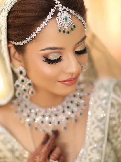 A close-up on modern elegance. This diamond and emerald set is for the bride who wants a chic, contemporary look. The clean design of the matha patti and the sparkle of the necklace add a luxurious finish, perfect for a reception or cocktail event.