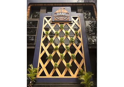 The facade of Dank, a commercial establishment where we integrated a vertical trellis with planters. This design creates a green entrance that is both visually interesting and aligned with a modern, urban aesthetic.