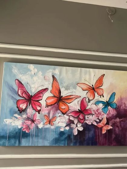 A beautiful texture canvas painting of colorful butterflies, seen here installed in a client's home. The abstract background and vibrant wings bring a sense of life and movement to the wall.