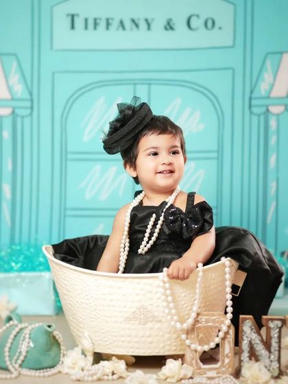 A classic pose from the Tiffany & Co. theme, complete with the iconic storefront backdrop. This is a chic and memorable way to celebrate a milestone.