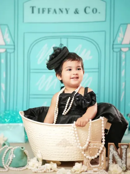 A classic pose from the Tiffany & Co. theme, complete with the iconic storefront backdrop. This is a chic and memorable way to celebrate a milestone.