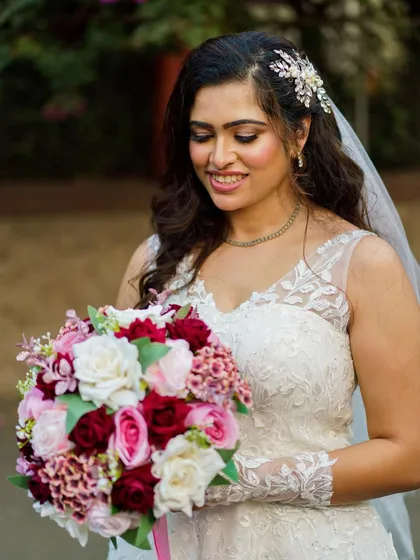 A portrait of our Catholic bride, looking radiant and holding her beautiful bouquet of red and pink roses. The makeup is soft and romantic.