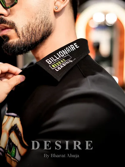 Power isn't just worn, it's stitched in. A close-up of the 'Billionaire Loading' embroidery on the collar, a detail for the man with ambition.