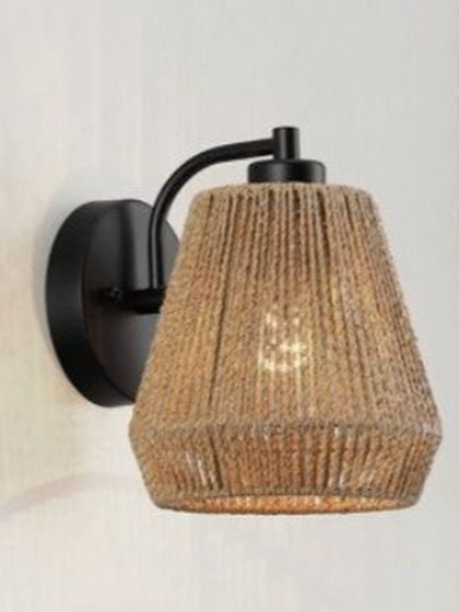 A close-up of our handcrafted jute wall sconce. The tight weave of the natural fiber creates a warm, textured shade that diffuses light beautifully, making it an ideal choice for ambient lighting.