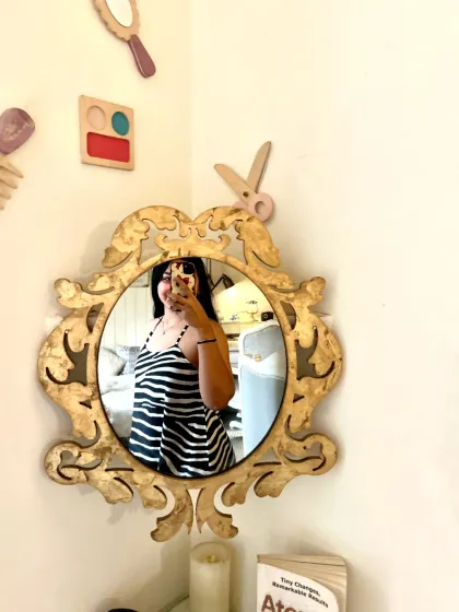 Our vintage mirrors are perfect for capturing your look. A guest takes a selfie, reflecting the cozy and stylish ambiance of the cafe corner.