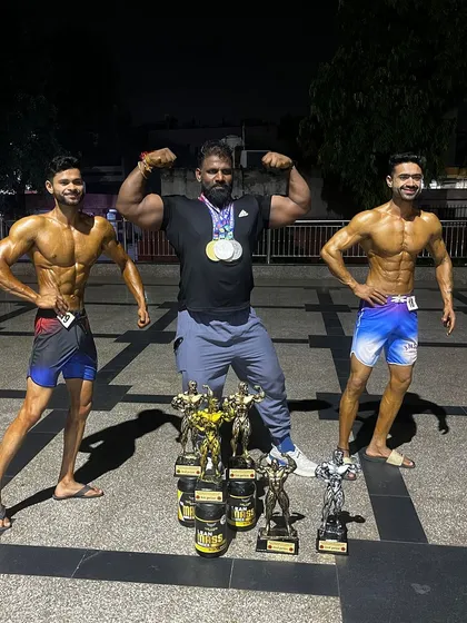 The result of teamwork and relentless effort. Posing with my two champions and their collection of trophies after the Mr. India competition. When my athletes win, I win.