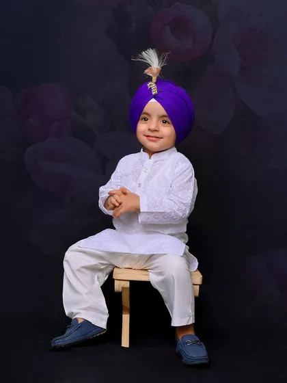 A posed portrait of the young boy, sitting calmly and looking at the camera. This shot demonstrates the ability to capture both playful and formal portraits during a single session.