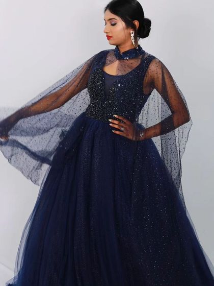 A final look at the navy blue gown, with the model showcasing the movement and sparkle of the cape.