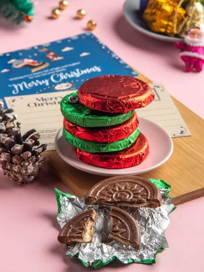 A stack of our chocolate-coated biscuits, wrapped in festive red and green foil. These are great for gifting or sharing.