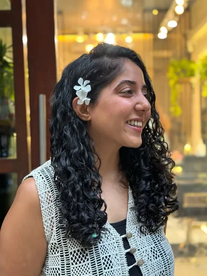 I had so much fun styling this real-life Moana. Her beautiful, long curls are accessorized with flowers and clips, showing how versatile curly hair can be.