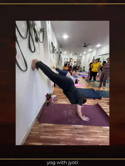 This student holds a strong line in a wall-supported handstand, demonstrating focus and developing arm strength.