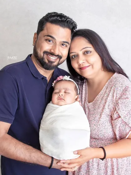 A beautiful family portrait with their sleeping newborn. Their smiles say everything. These are the memories that become family heirlooms.