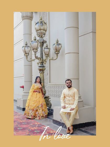 A posed couple portrait against a grand architectural backdrop during their mehendi or haldi event.