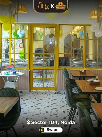 The bright and airy indoor dining section, decorated with yellow window frames and party balloons. It's a cheerful space for a family meal or a birthday feast.