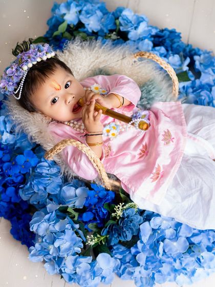 Lying in a basket of flowers, this baby Krishna looks absolutely divine. I use creative props to capture unique and artistic portraits.