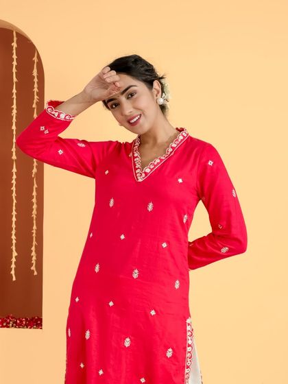 This image from the red kurta series captures a playful and lighthearted moment. It showcases the full garment in a dynamic pose, bringing energy and life to the brand's collection.