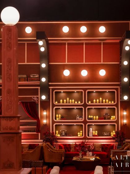 The lounge areas featured comfortable seating nooks with candle-filled shelves and warm, ambient lighting. The design focused on creating intimate spaces within the larger venue for guests to relax and socialize.