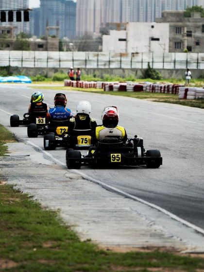 A train of karts snakes through the track during a race, showing the close competition.