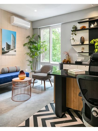 The manager's cabin combines functionality with an informal aesthetic. A patterned floor defines the desk area, while a comfortable seating nook provides space for meetings or relaxation.