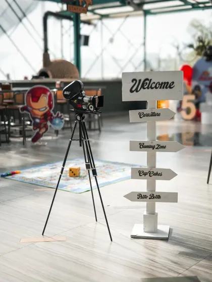 We guide the little heroes to all the fun zones. This custom directional sign points the way to caricatures, the gaming zone, cupcakes, and the pizza booth.