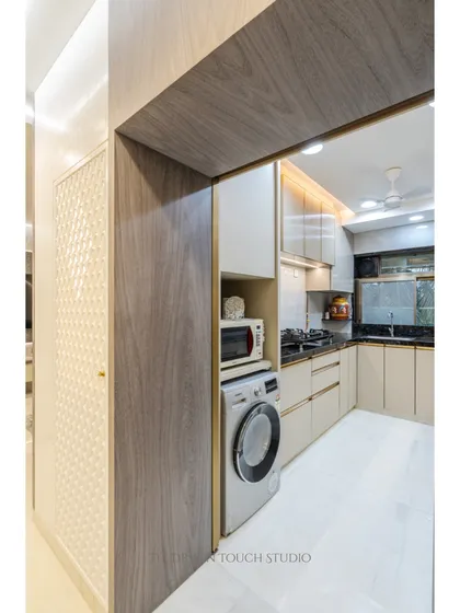 A view into the kitchen from the entrance, showing the integrated microwave and washing machine. This demonstrates our ability to create highly functional utility zones within the kitchen space.