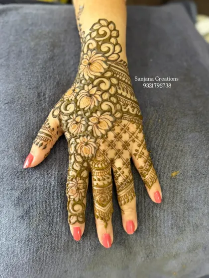 A beautiful floral design that flows diagonally across the hand, combining bold flowers with fine net patterns.