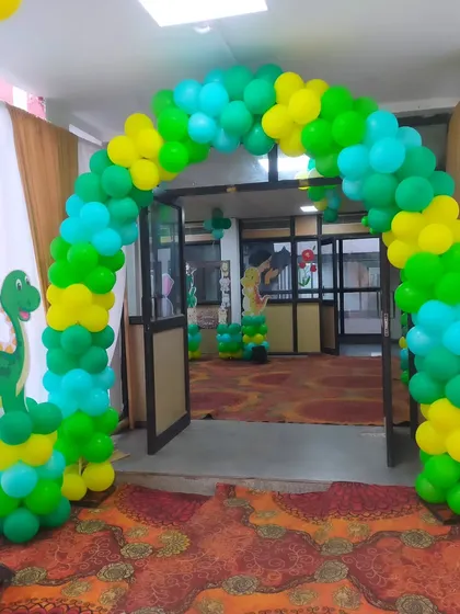 A simple balloon arch at the entrance of the jungle-themed party venue.