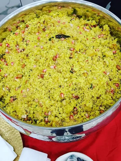 A large bowl of delicious poha, garnished with fresh pomegranate seeds. This light and healthy dish is a popular choice for my breakfast and high tea menus.