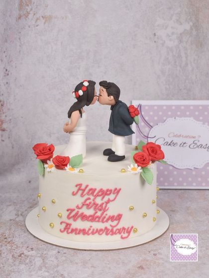 A sweet and simple cake for a first wedding anniversary. The kissing couple topper is handmade from fondant and makes for a romantic centerpiece.