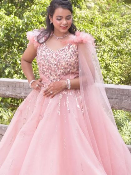 A full shot of the pink princess gown in an outdoor setting. The soft color and voluminous skirt make it a picture-perfect choice for a day event.