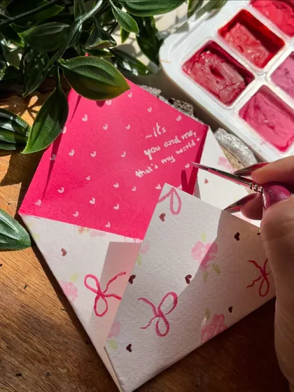 Unwrap the joy! A close-up of a hand-painted envelope with a personal note inside, ready for gifting.