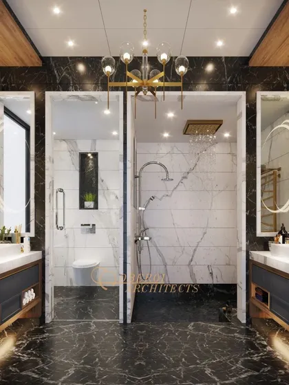 Marble moments and golden accents define this luxurious his-and-hers bathroom, featuring separate vanities and a central shared shower area.