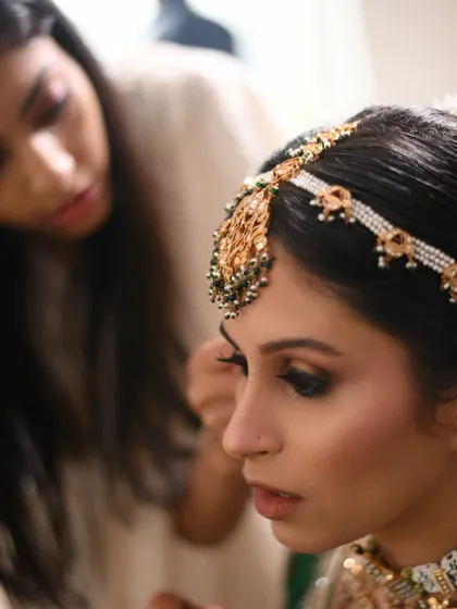A behind-the-scenes shot of our artist perfecting the bride's eye makeup. This shows the precision and attention to detail that goes into every bridal application.