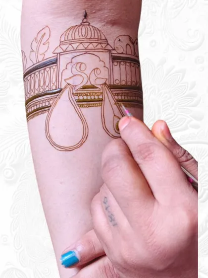 A live class demonstration of mehendi application on an arm. I guide my students through each step, showing them how to outline and fill intricate bridal elements.