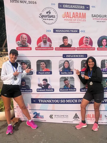 It's always special to see our runners recognized as influencers in the community. Here, two of our athletes celebrate their race in front of the event banner, a proud moment for all of us.