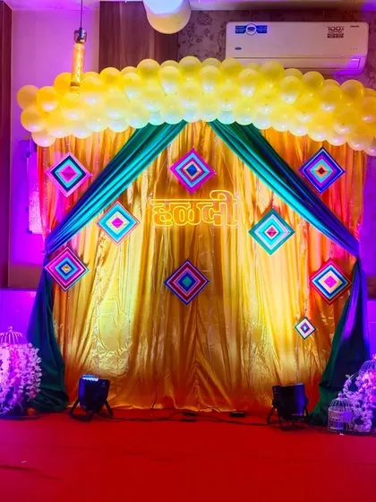This is a vibrant Haldi ceremony stage I decorated. I used bright yellow and green drapes, a custom "Haldi" neon sign, and traditional motifs to create the perfect festive backdrop for this important pre-wedding function.