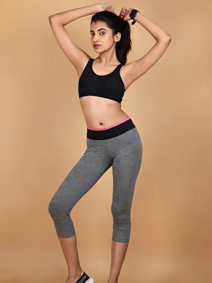 A clean studio shot for an activewear or fitness apparel brand. The simple background and clear lighting ensure the focus remains on the fit and style of the clothing.